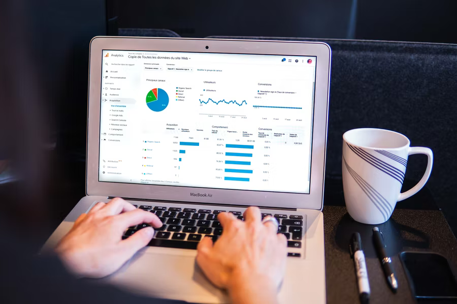 A person reaches out to type on a laptop keyboard that has a nonprofit CRM dashboard pulled up