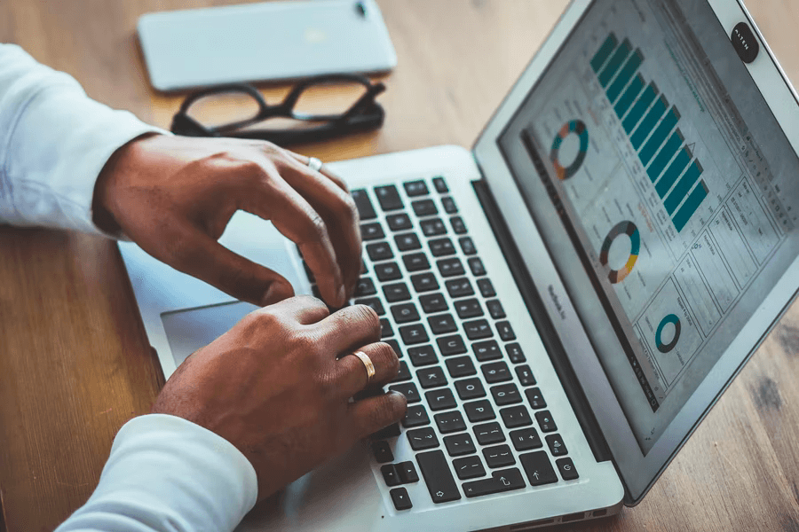 A man uses his laptop to check on the analytics for his nonprofit online fundraising efforts.