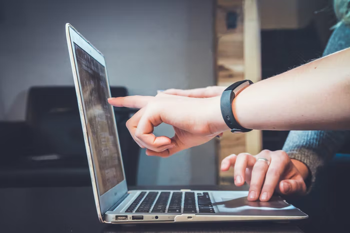 Two people work on a laptop to set up a volunteer management software for nonprofits.