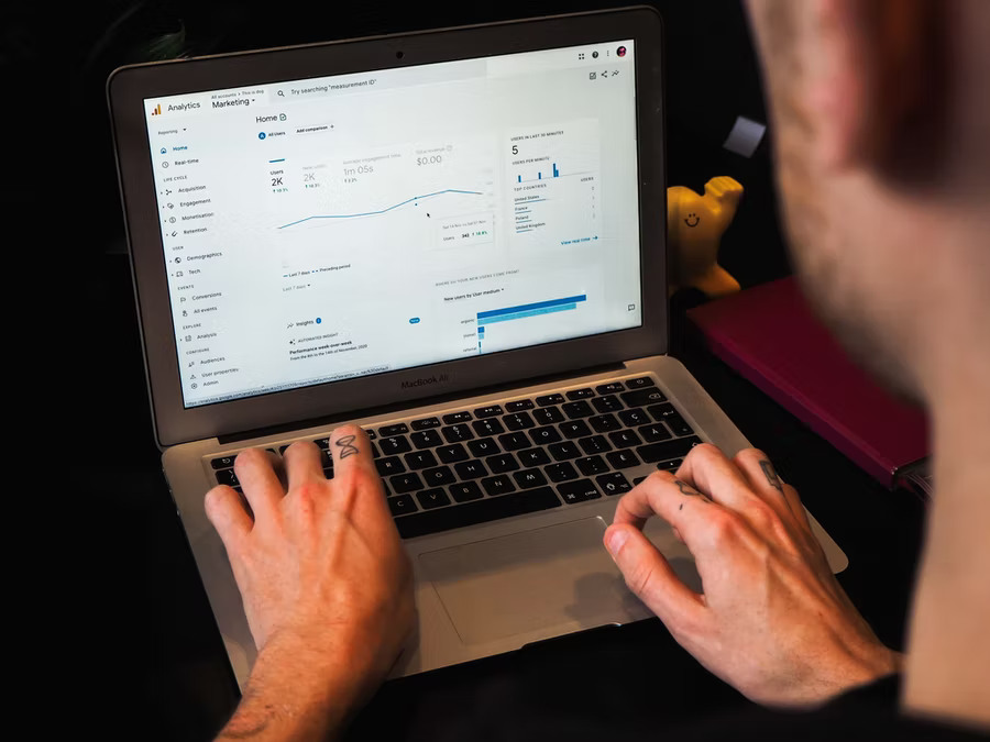 A man uses his laptop to pull Google Analytics reports for his nonprofit organization.
