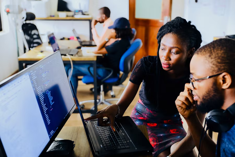 Two people work together on a computer to improve their nonprofit organization.