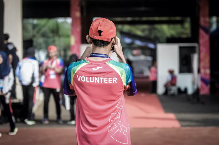 A volunteer stands with his back to the camera as he helps a nonprofit during an event.