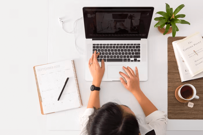 A person uses her laptop to open her nonprofit CRM software.