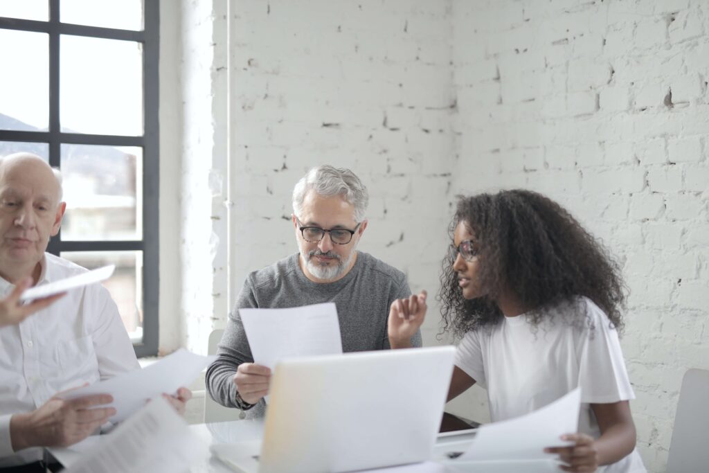 A group of nonprofit professionals look over reviews to decide the best free nonprofit resources to use for their organization