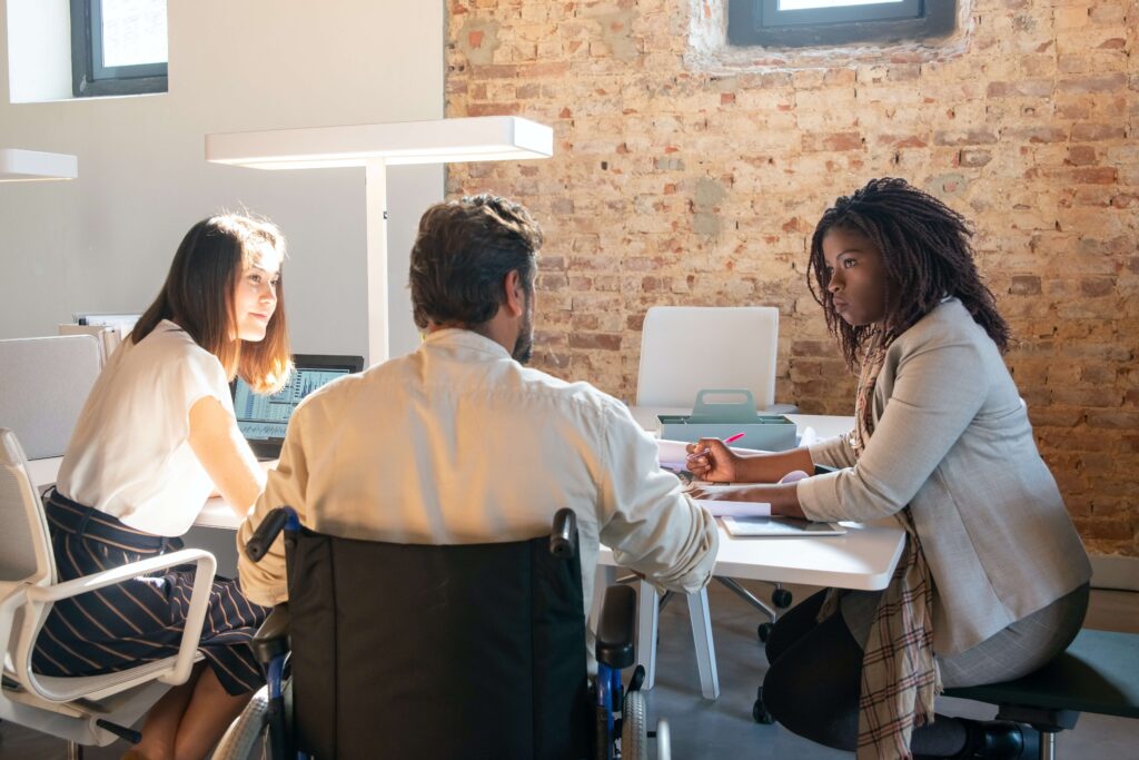 A group of three nonprofit professionals work together at a table for their organization