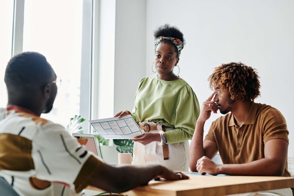 A woman shows two men the content marketing strategy for nonprofits she created