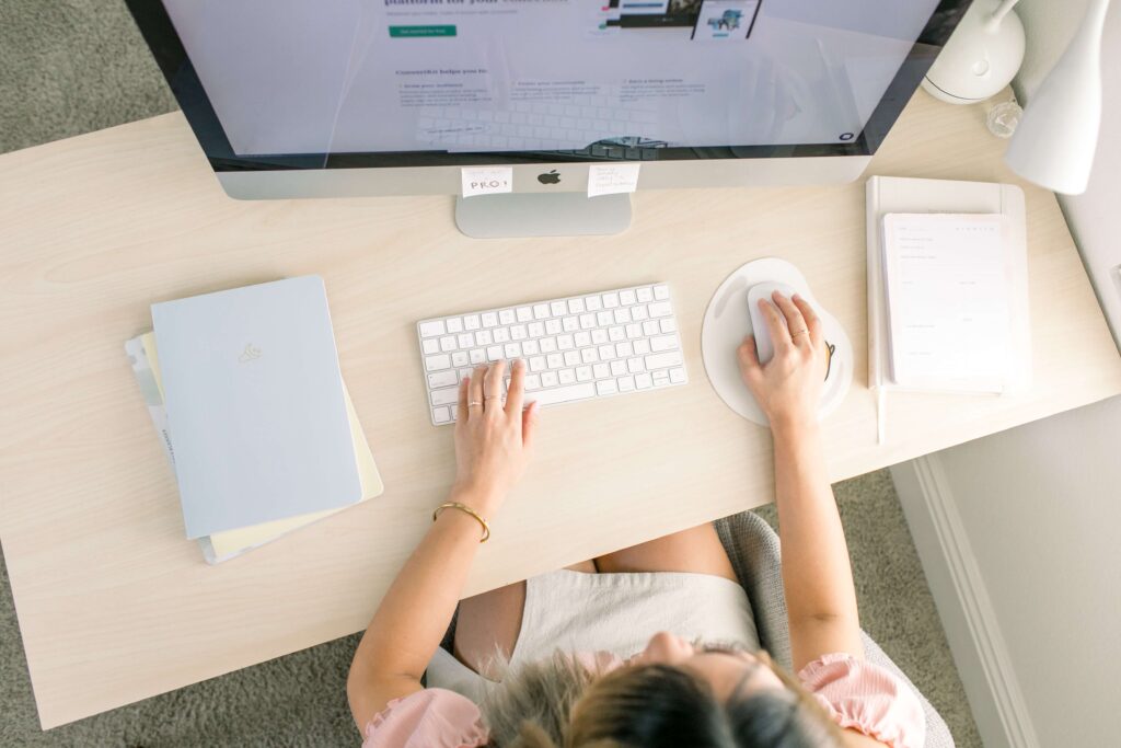 A woman sits at a large Apple computer to work on her nonprofit’s website.