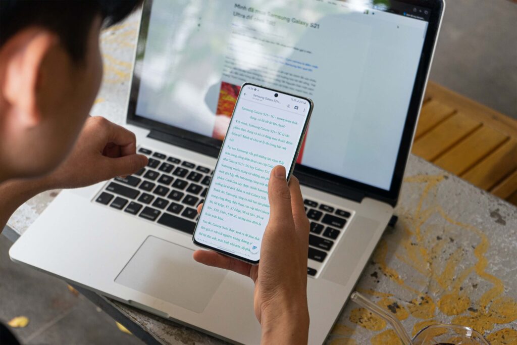 A young person has his laptop open in front of him while reading a nonprofit monthly newsletter email