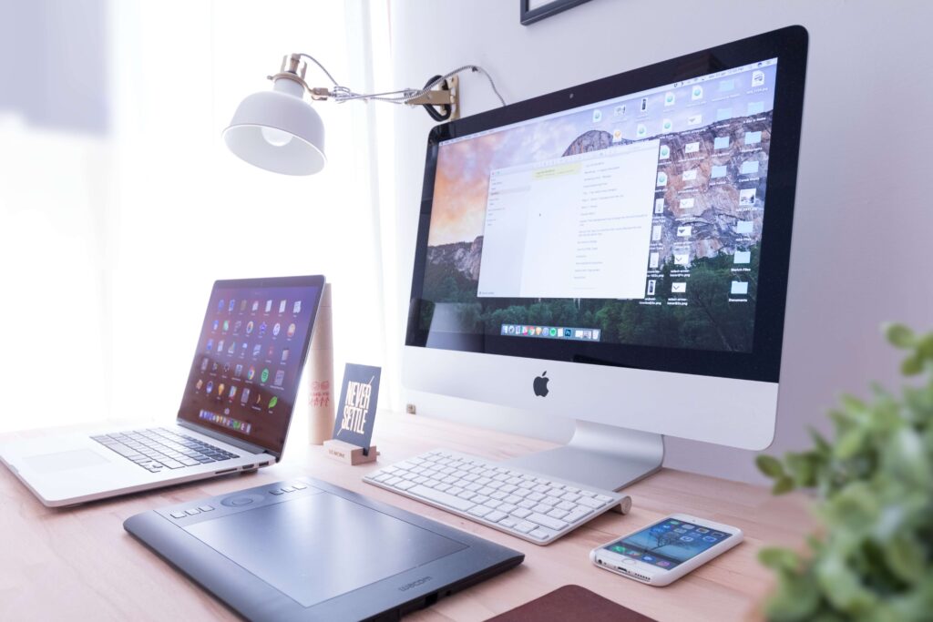 A desktop, laptop, and tablet sit on a desk after purchased from a nonprofit technology grant. 