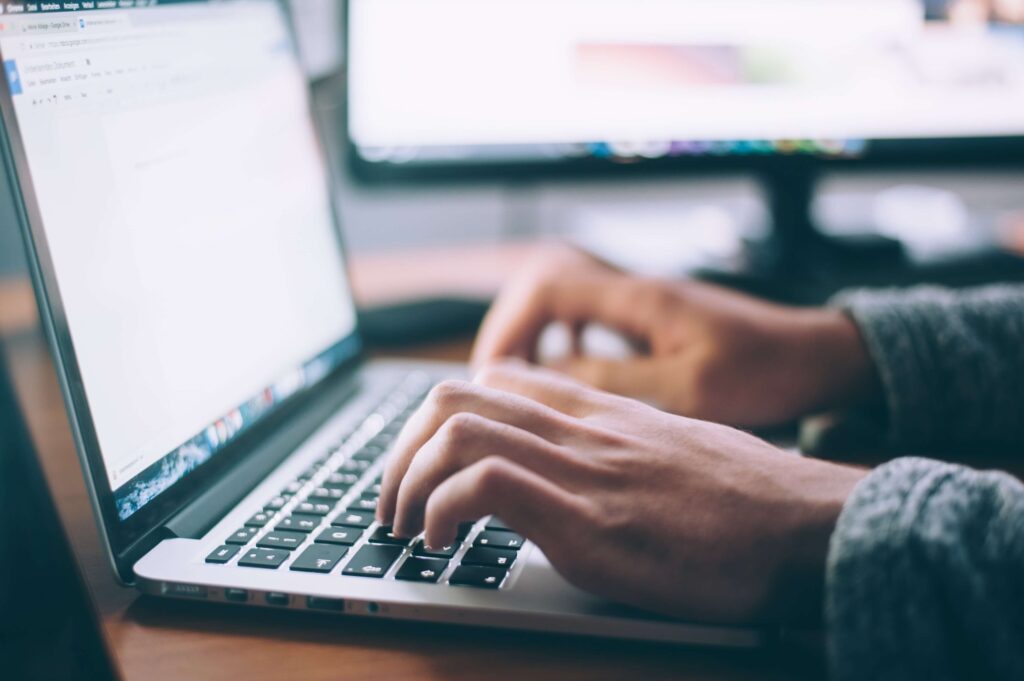 A person uses a computer purchased from a nonprofit technology grant. 