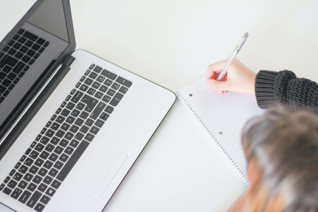 A person writes on a notepad as she takes courses for nonprofit professional development.