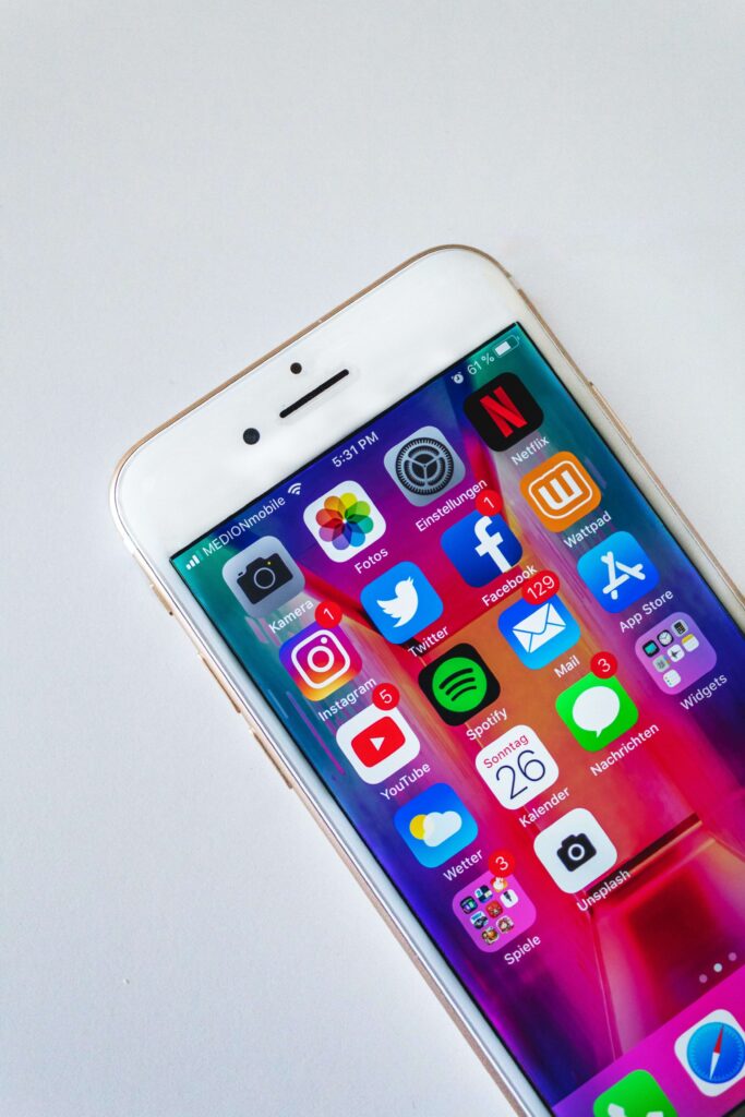 An iPhone on a white table shows the different nonprofit social media apps. 