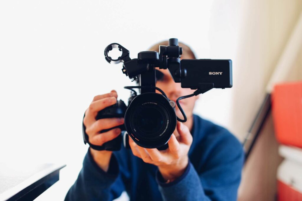 A person uses a camera to film video marketing material for nonprofits. 