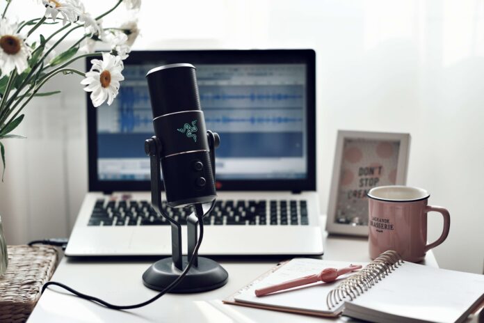 An external microphone sits in front of a laptop as a nonprofit professional gets ready to record podcasts for nonprofits.