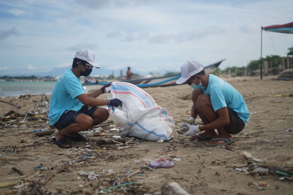 Two volunteers for a nonprofit work to clean up the beach from trash. 
