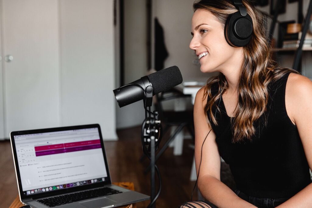 A nonprofit professional speaks into a microphone as she records a podcast episode. 